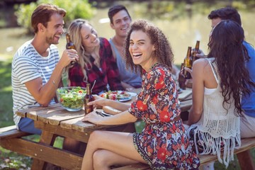 Happy friends in the park having lunch