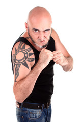 Violent man with tattoo is threatening by fists