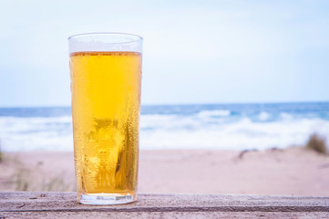 Glass of beer on the beach