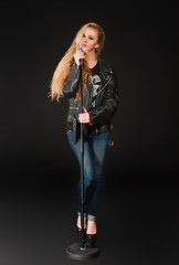 Beautiful blonde woman singing to microphone