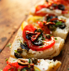 Sandwich with tomatoes,capers, olives, feta cheese and herbs