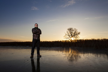 man standing on a frozen lake