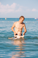 Happy father and baby having fun in the sea