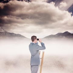 Composite image of businessman looking on a ladder