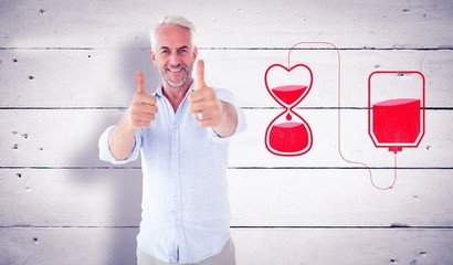 Composite image of smiling man showing thumbs up to camera
