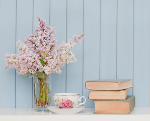 Bunch of lilac, books and teacup