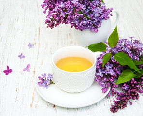 Cup of tea and lilac flowers