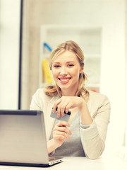 happy woman with laptop computer and credit card