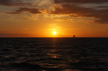 Naklejka na ściany i meble Sonnenuntergang auf dem Meer mit Segelschiff