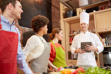 happy friends with tablet pc in kitchen