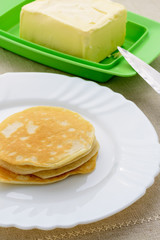 On a white plate stack of pancakes