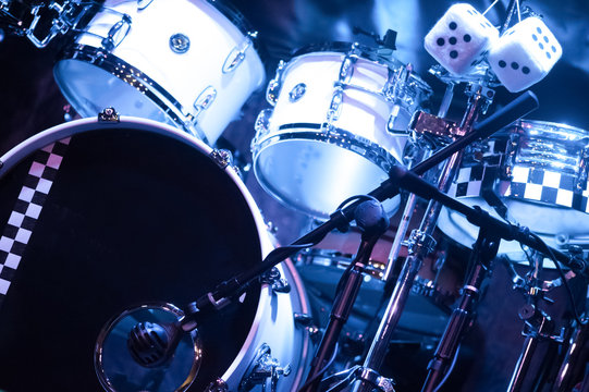 blue spotlight illuminating a drumkit on stage