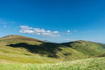 Cloud shadows on the green fields of spring mountains