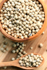 white pepper seeds on wooden background.