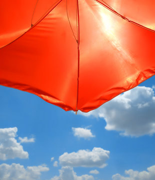 Red Beach Umbrella over cloudy sky