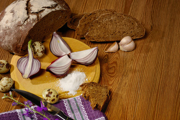 bread black head of garlic and onion halves knife and fork