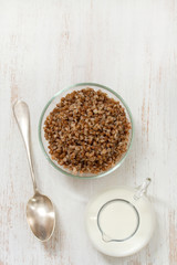buckwheat in bowl with milk and spoon