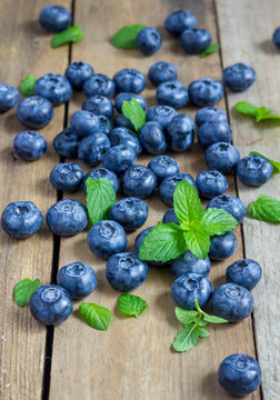 Blueberries decorated with mint on a wooden table