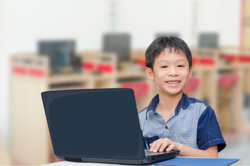 Little Asian boy using notebook computer