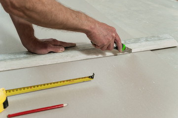 Man cuts off a piece of drywall