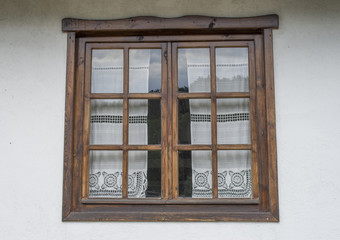 Wooden window with white lace curtains
