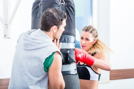 Junge Frau mit Trainer beim Boxen