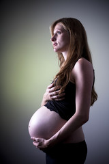 Mujer rubia embarazada con fondo amarillento