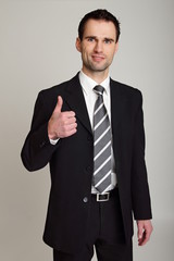 Handsome businessman in suit shows you thumb up