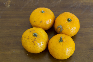 orange on wooden table on brown background