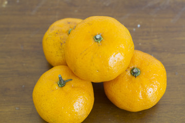 orange on wooden table on brown background