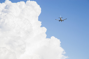 Aereo con carrello abbassato vicino ad una nuvola