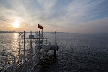 Sunset over the sea, pierce and Turkish flag, Istanbul