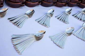 Insieme di cucchiai aperti a ventaglio su tavolo apparecchiato