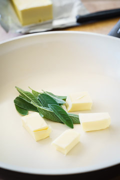 Closeup of Butter and Fresh Sage Leaves in the Ceramic Pan
