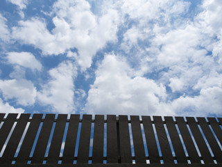 Brown fence with blue sky background.