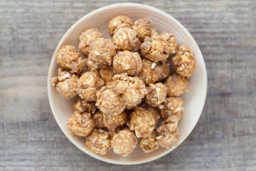 Almond and caramal popcorn on wood background
