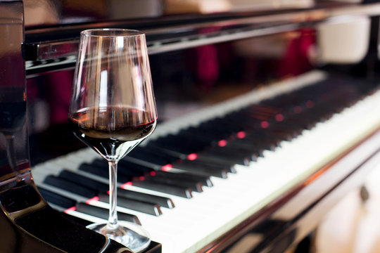 Fototapeta red wine glass and piano