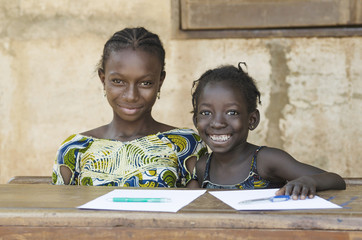 Two African Ethnicity Children Smiling Studying in a School Environment