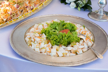 Totano a cubetti con insalata riccia presentato su vassoio argento