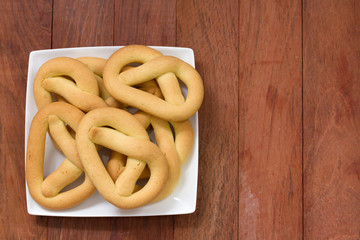 cookies in plate on brown wooden background