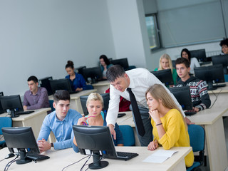 students with teacher  in computer lab classrom