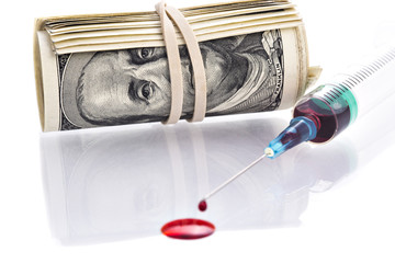 Blood drops from syringe needle with 100 dollars banknotes rollo