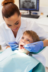 female dentist examining little patient