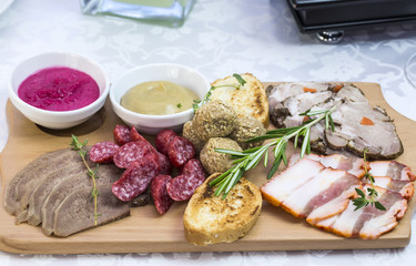 wooden dish with bacon and sausage on a white background