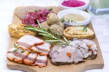 wooden dish with bacon and sausage on a white background
