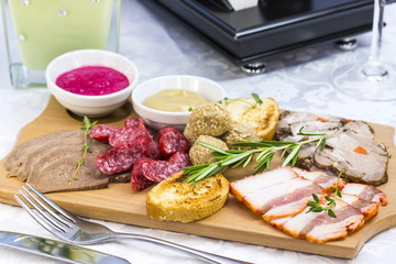 wooden dish with bacon and sausage on a white background