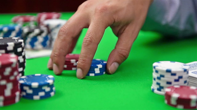 dealer collects poker chips from the table