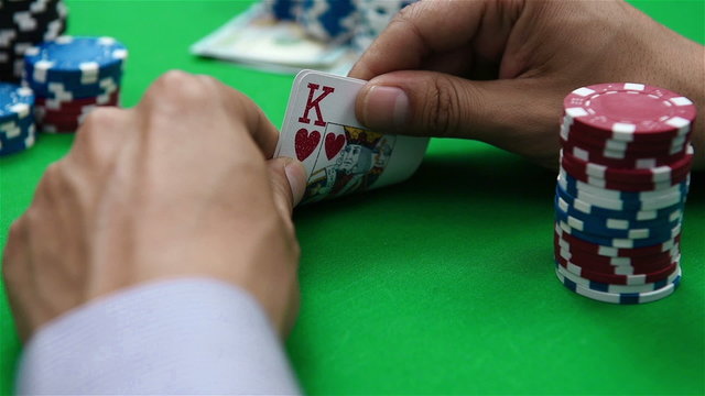 poker player looks at the card and bet