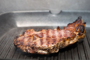 frying beef steak on a ribbed grill pan