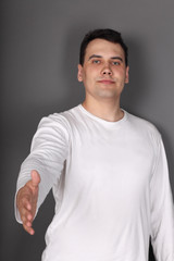 Obraz premium Young beautiful man holds out his hand for handshake